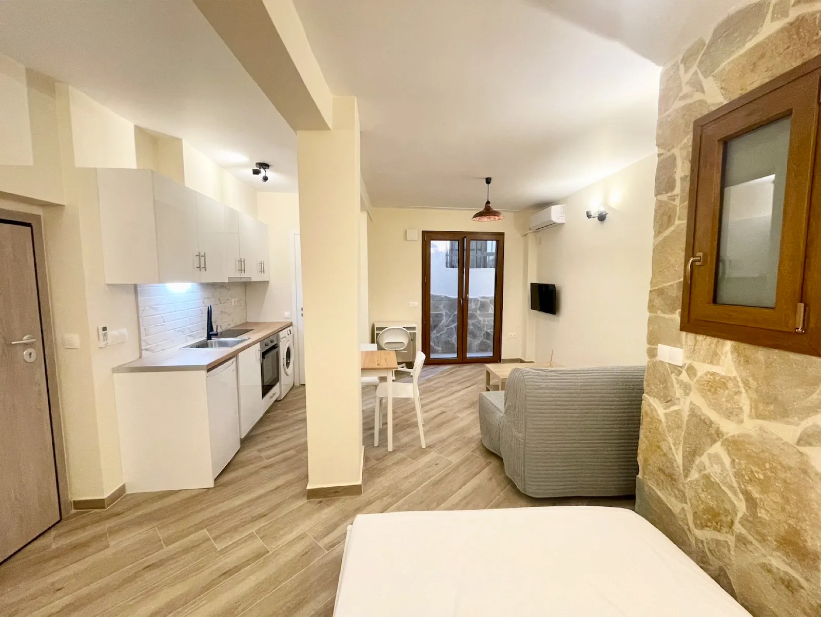 Studio with a stone wall and sitting area in an Athens apartment